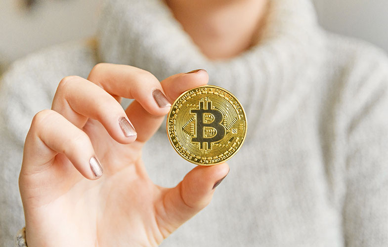 106820278 1609972654383 hand holding a bitcoin in front of a computer screen with a dark graph blockchain mining bitcoin t20 pRrrjP